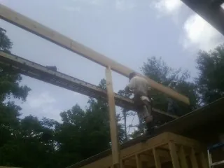 Carpenter setting a ridge beam over a new addition frame — Ice Dam Removal by Roofing Brothers in Little Silver