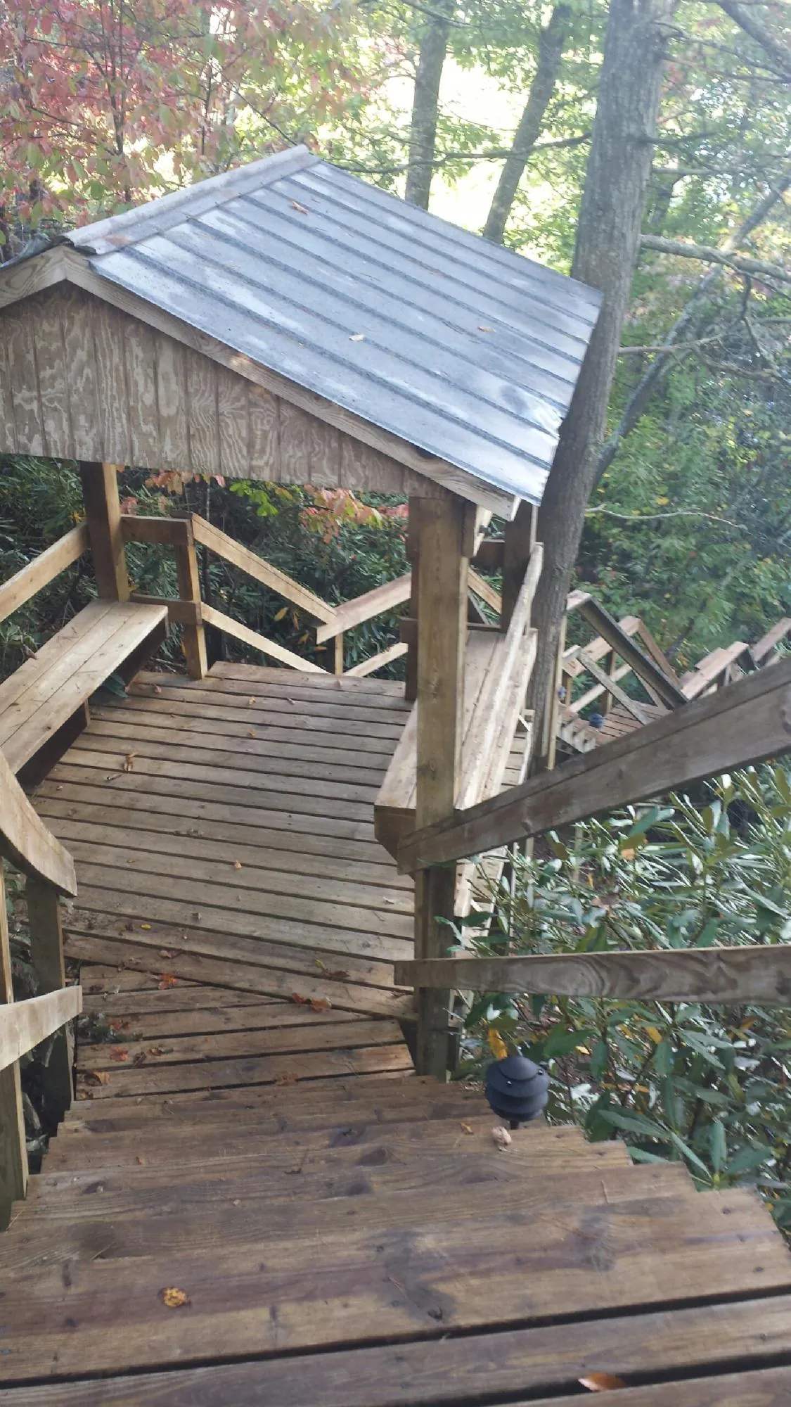 Metal roofed shelter over wooden steps on a wooded walkway — Skylight Repair & Installation work by our crew in Little Silver