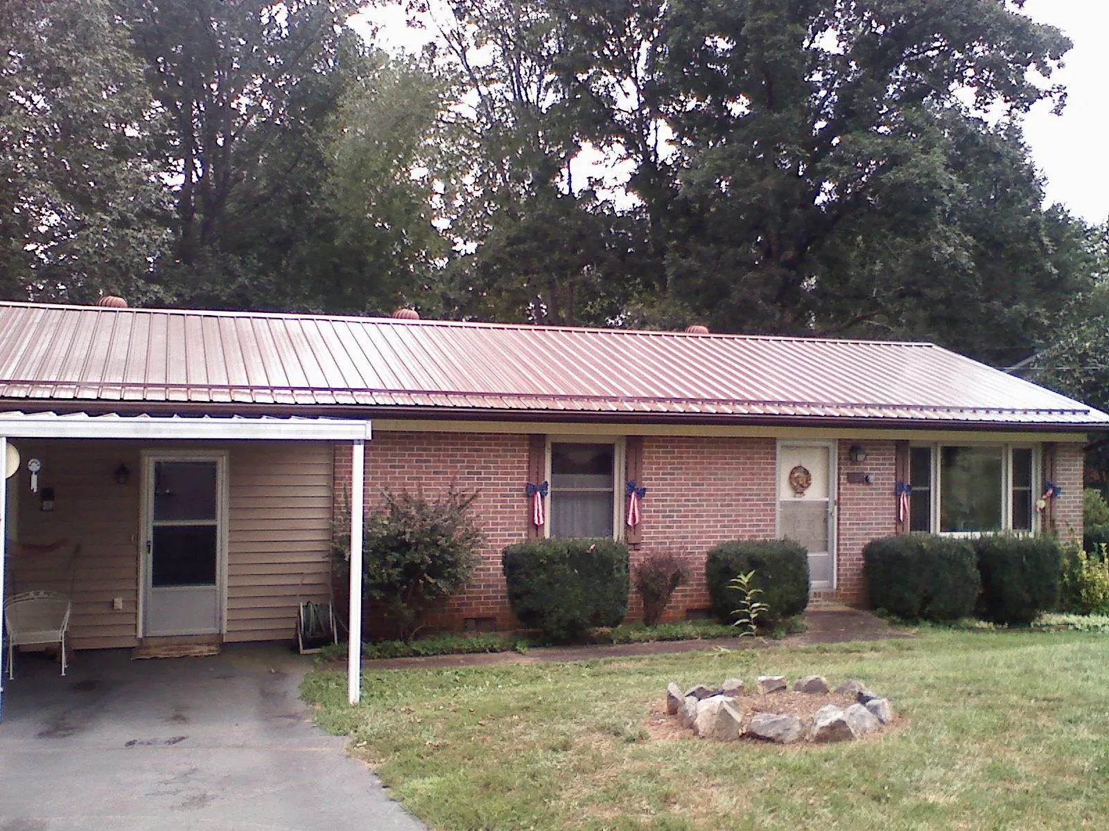 Bronze metal roof and carport on a brick ranch home — Roof Repair work by our crew in Little Silver